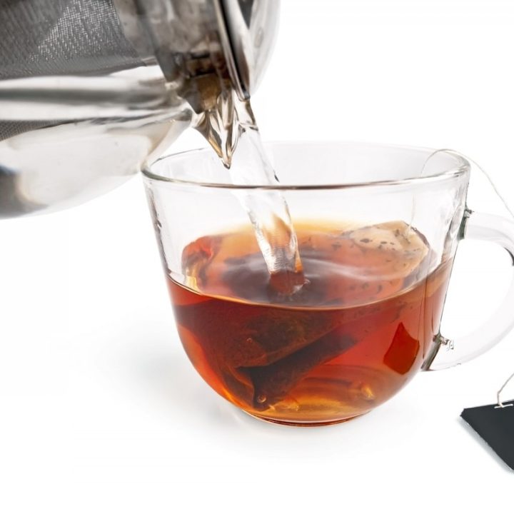 Tea from a bag in a glass cup with a teapot