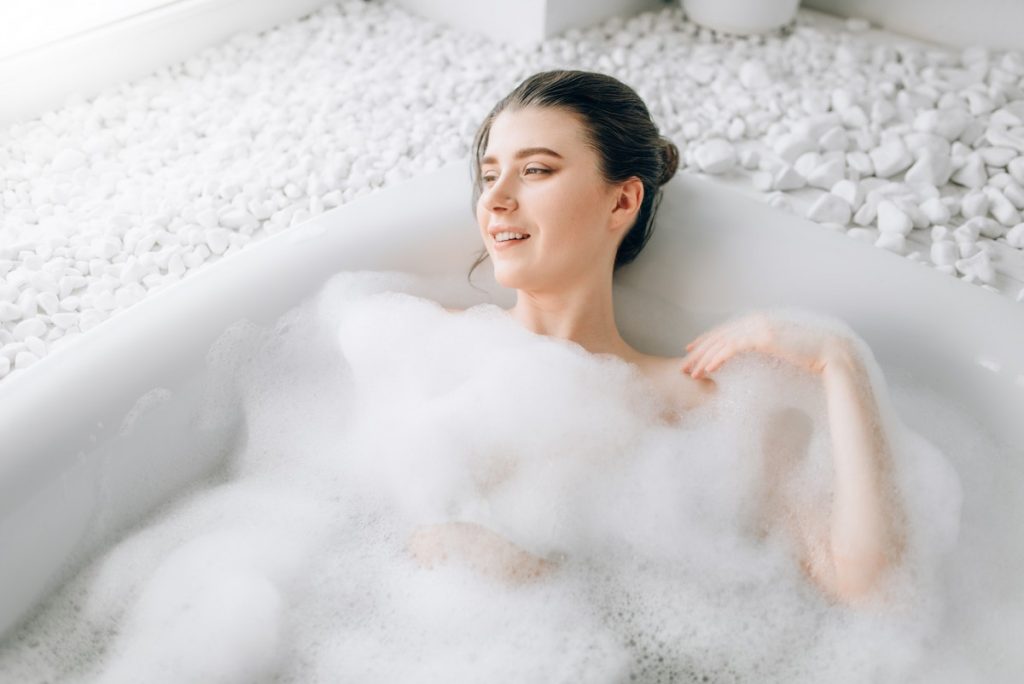 19 Ridiculously Easy Home Spa Treatments; Attractive lady lying in bath with foam, top view