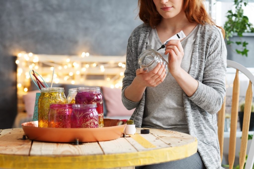 How To Make A DIY Spa Kit Without Breaking The Bank: 8 Ways; Woman painting jar at home