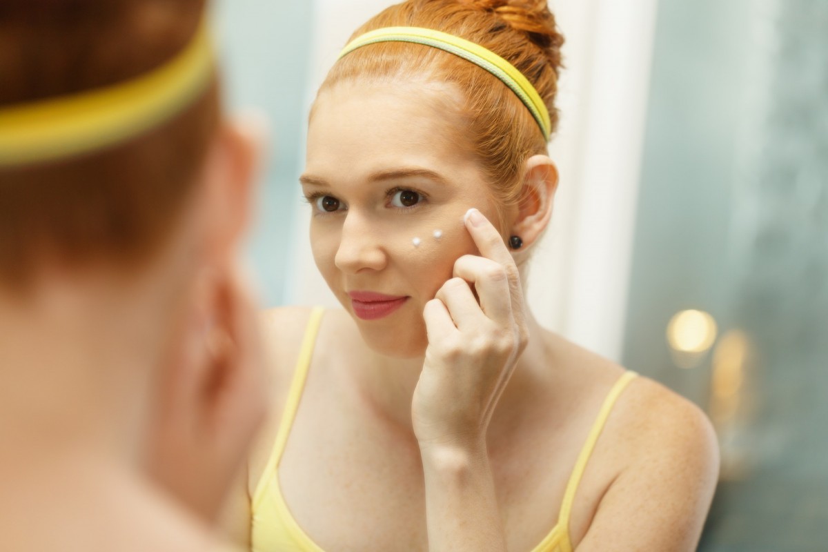 How To Use Bakuchiol For Anti-Aging And Skin Conditions; Young Woman Applies Anti-Aging Cream Looking At Mirror